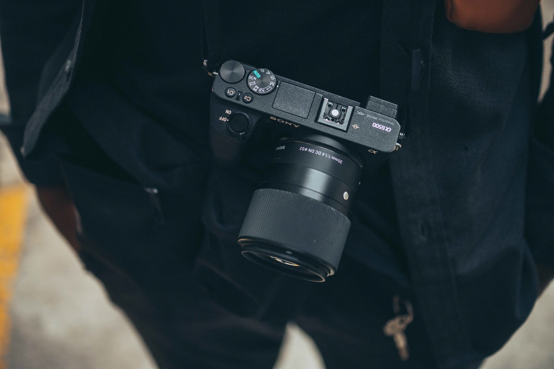 Eine Sony Alpha Kamera hängt einem Fotografen um den Hals
