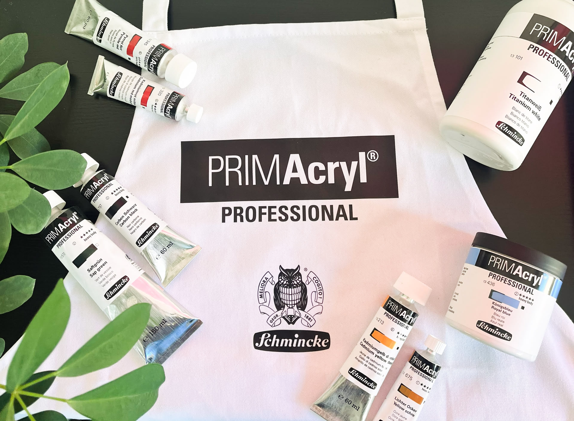 Farbbehälter liegen auf einer weißen Schürze von mit Schmincke Logo