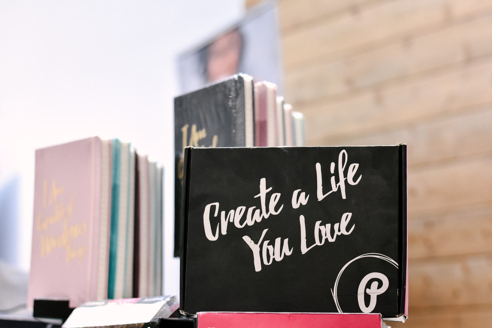Ein Notizbuch mit der Aufschrift "Create a Life You Love" steht vor anderen Notizbüchern