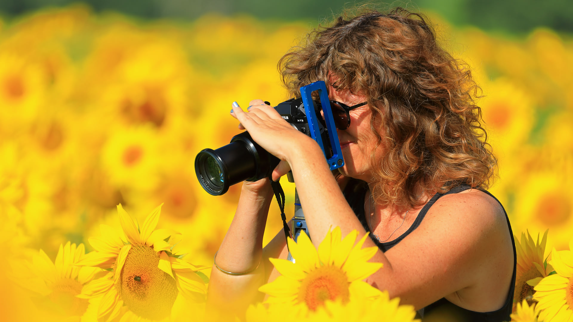 Frau mit Kamera in Sonnenblumen-Feld