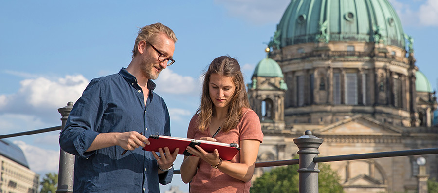 Dozent Jan Philipp Schwarz mit einer Kursteilnehmerin vor dem Berliner Dom